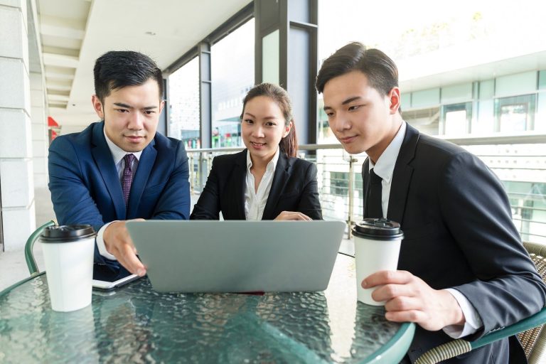 Business team reviewing company tax filing Singapore on a laptop
